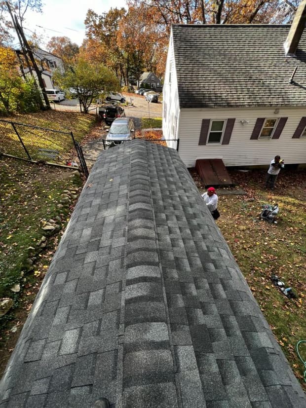 A finished asphalt shingle roof replacement, seen along the ridge.